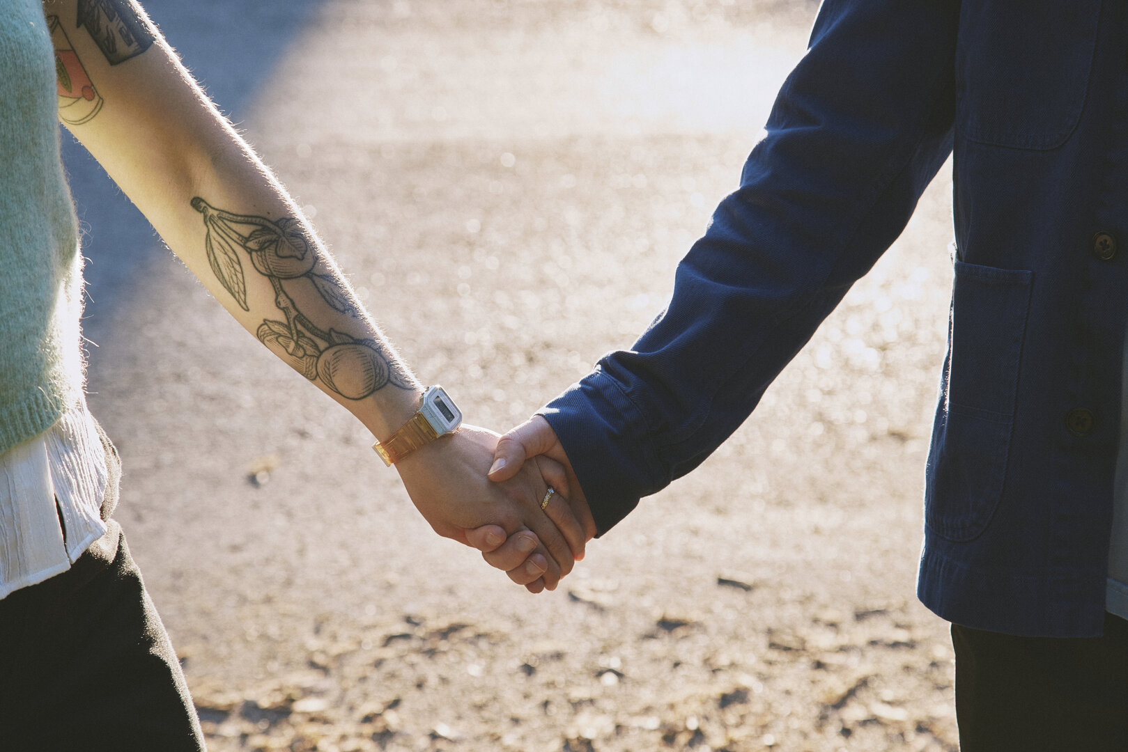 Close-up of Andy and Brit's hands holding with wedding ring visible